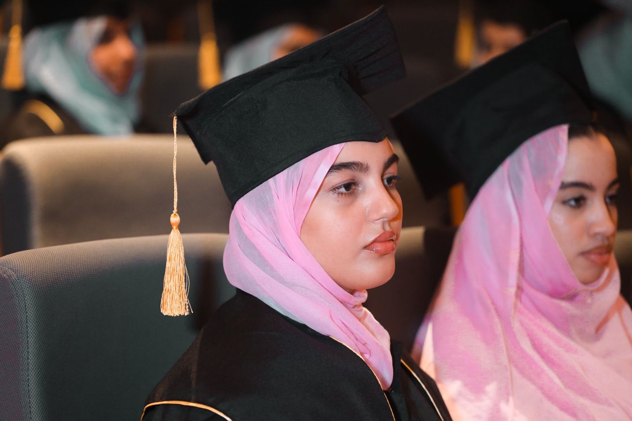 services-img Young women in hijabs and caps at a graduation ceremony, celebrating academic achievements.