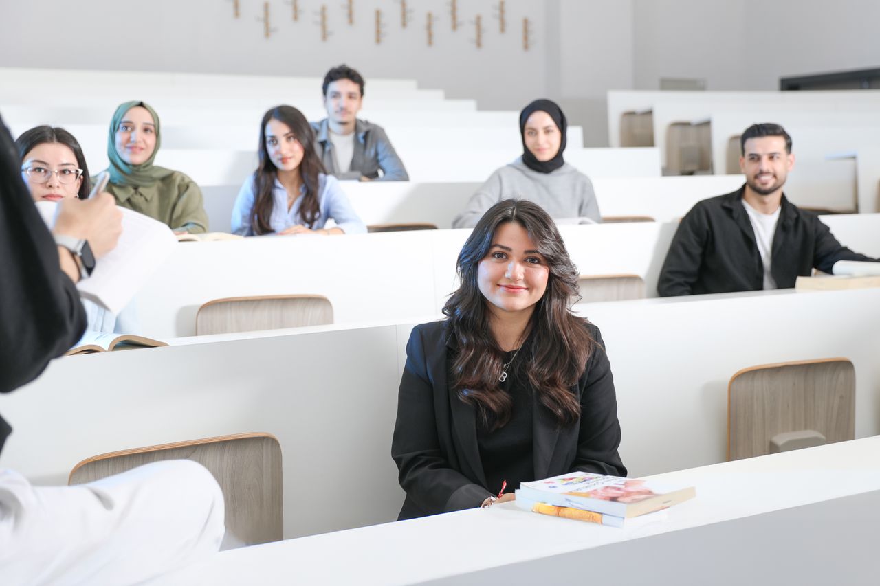 services-03 Students listening attentively in a bright university lecture hall.